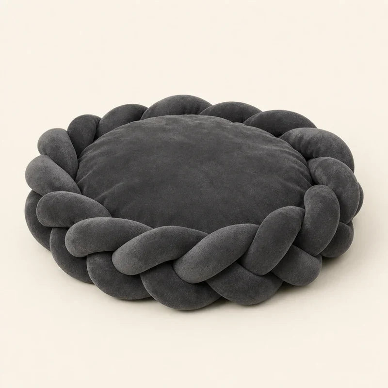 Panier chien design en daim tressé gris foncé posé dans un intérieur clair