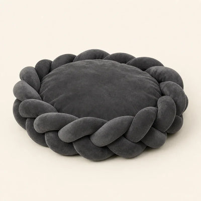 Panier chien design en daim tressé gris foncé posé dans un intérieur clair